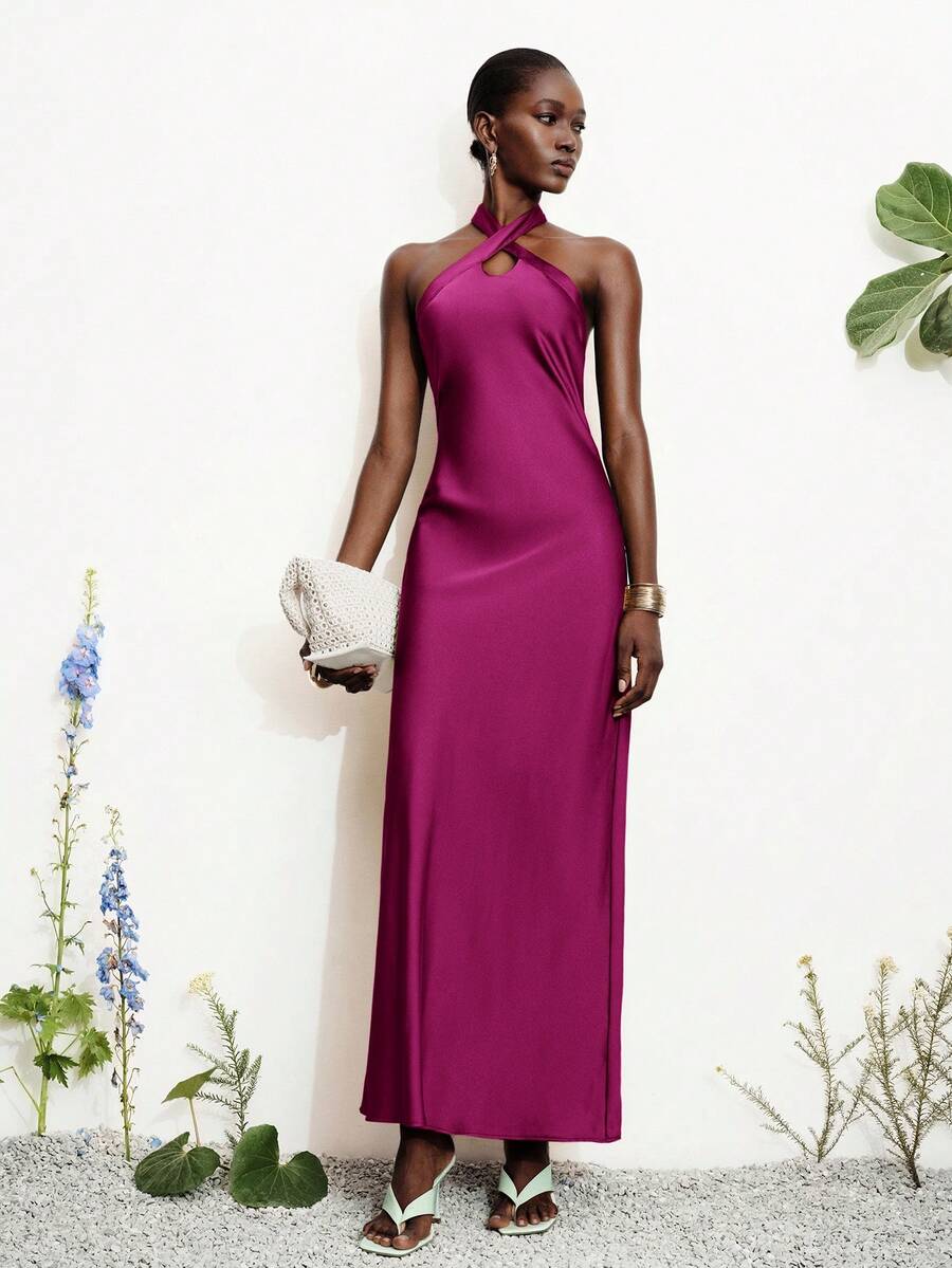 Women's black satin halter neck bodycon midi dress featuring a sleeveless backless design with front slit hem and wrap details.