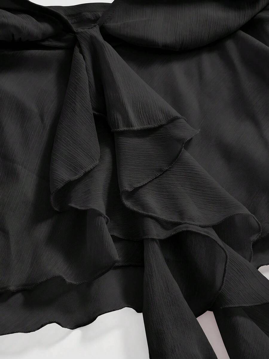 Black halter crop top featuring an asymmetrical ruffle hem and backless design for women.
