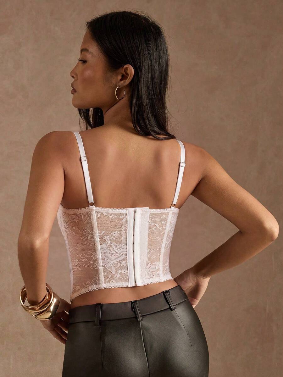 Black women’s lace cami top with spaghetti straps, contrast lace details, and an asymmetrical hem, styled as a slim-fit lined casual top.
