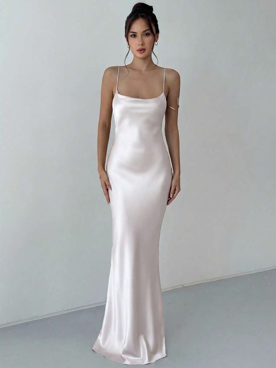 Beige satin backless maxi dress featuring criss-cross spaghetti straps and a mermaid hemline.