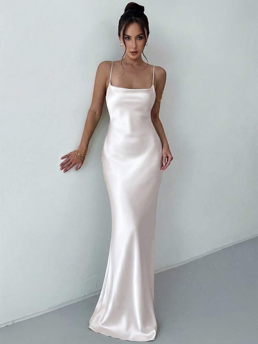 Beige satin backless maxi dress featuring criss-cross spaghetti straps and a mermaid hemline.