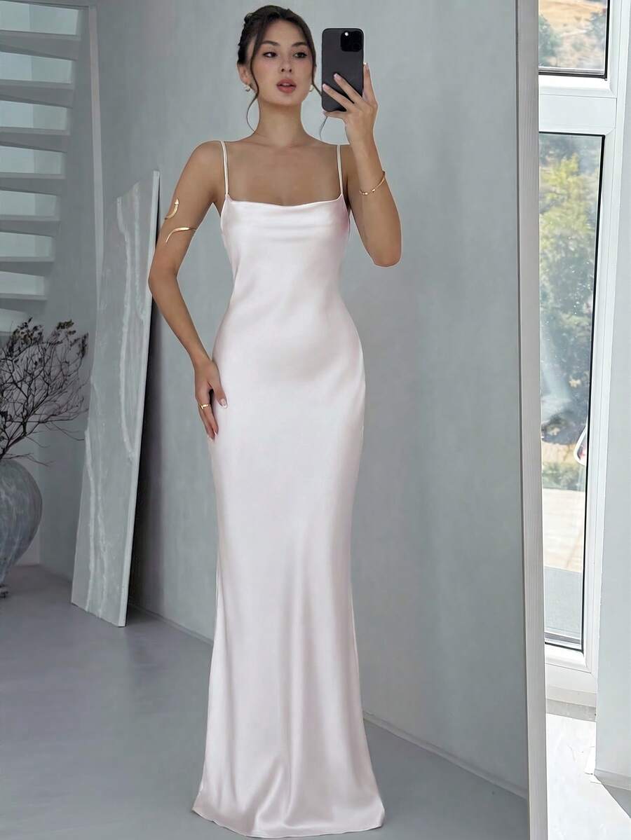 Beige satin backless maxi dress featuring criss-cross spaghetti straps and a mermaid hemline.