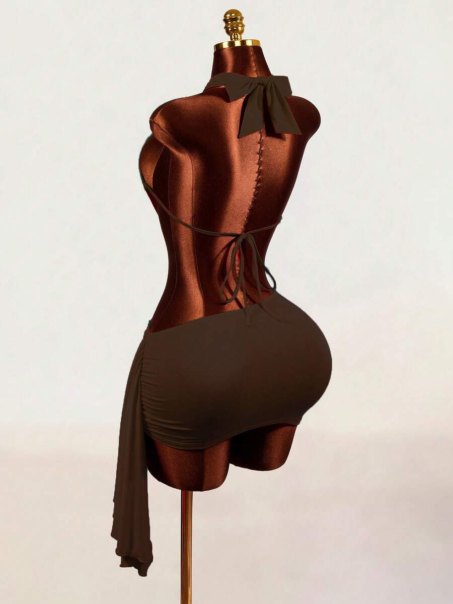 Women's black halter hollow out mini bodycon dress featuring backless asymmetrical knot details and a slim pencil fit.