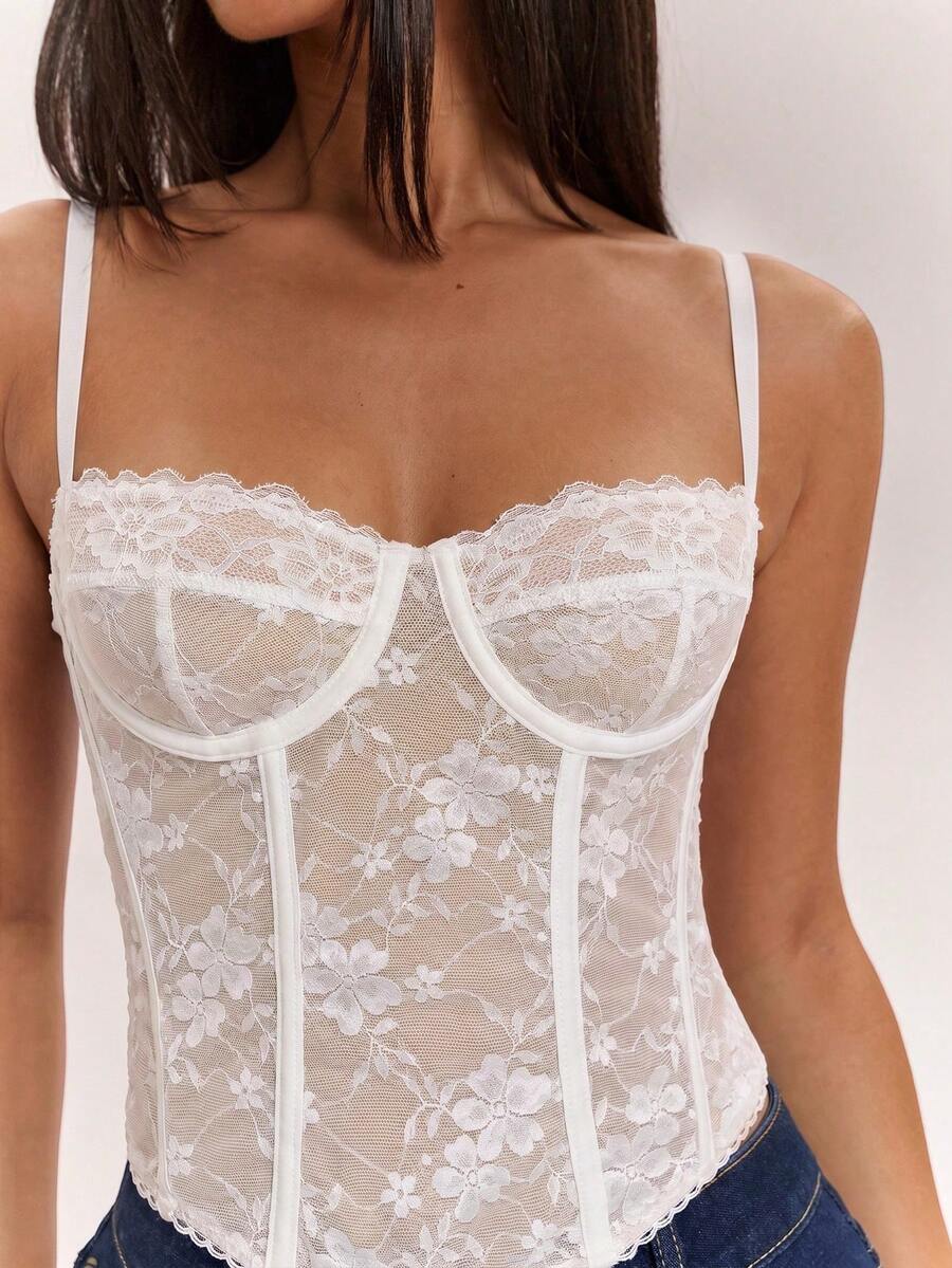 Black women’s lace cami top with spaghetti straps, contrast lace details, and an asymmetrical hem, styled as a slim-fit lined casual top.