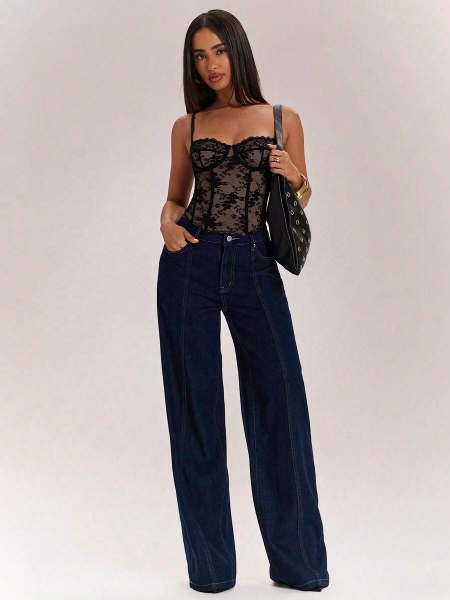 Black women’s lace cami top with spaghetti straps, contrast lace details, and an asymmetrical hem, styled as a slim-fit lined casual top.