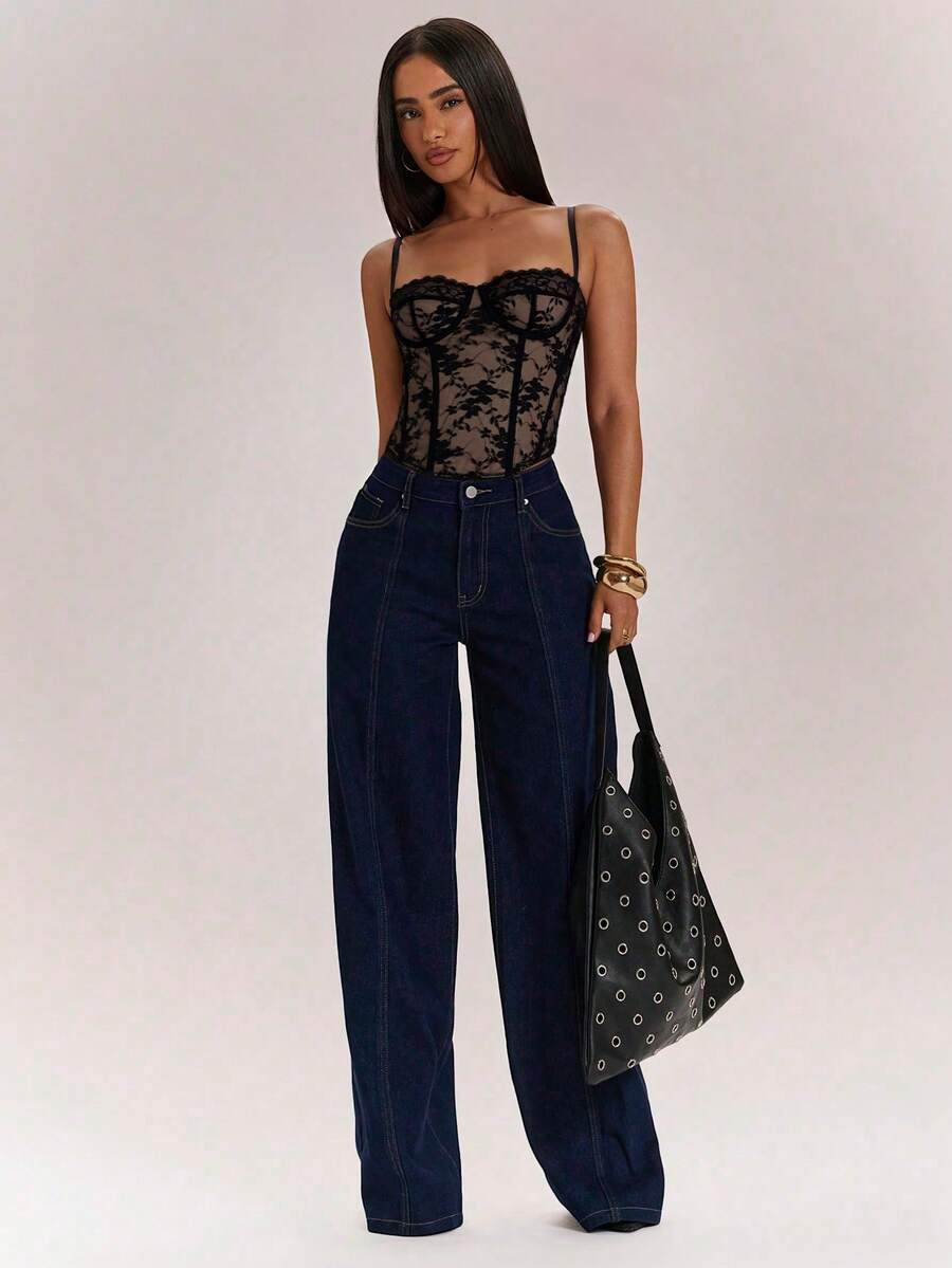 Black women’s lace cami top with spaghetti straps, contrast lace details, and an asymmetrical hem, styled as a slim-fit lined casual top.
