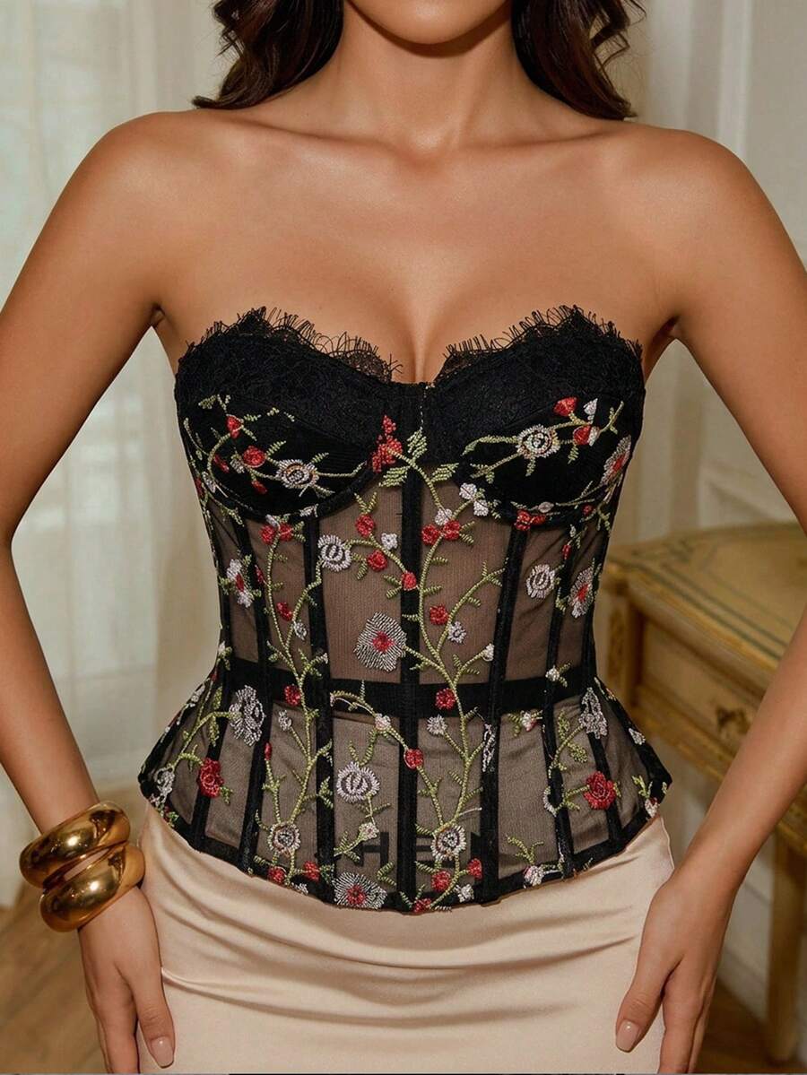 Women's black lace boned strapless bandeau crop top featuring semi-sheer baroque embroidered detail, slim fit silhouette, and asymmetrical hem.