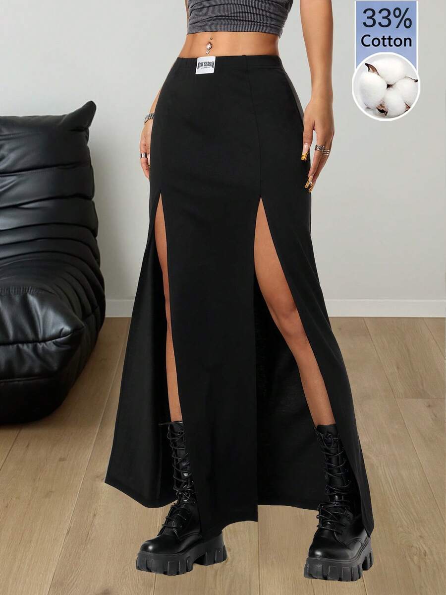 Women's black high waist long skirt with split thigh slit, zipper, and letter patch detail made from knitted stretch fabric.