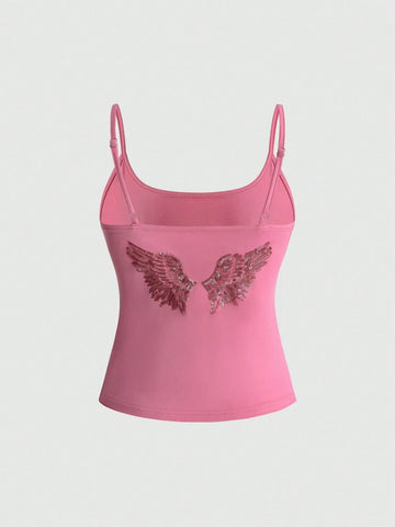 Women's pink cropped spaghetti strap tank top featuring a rhinestone wing design on the back in a slim fit knit style.