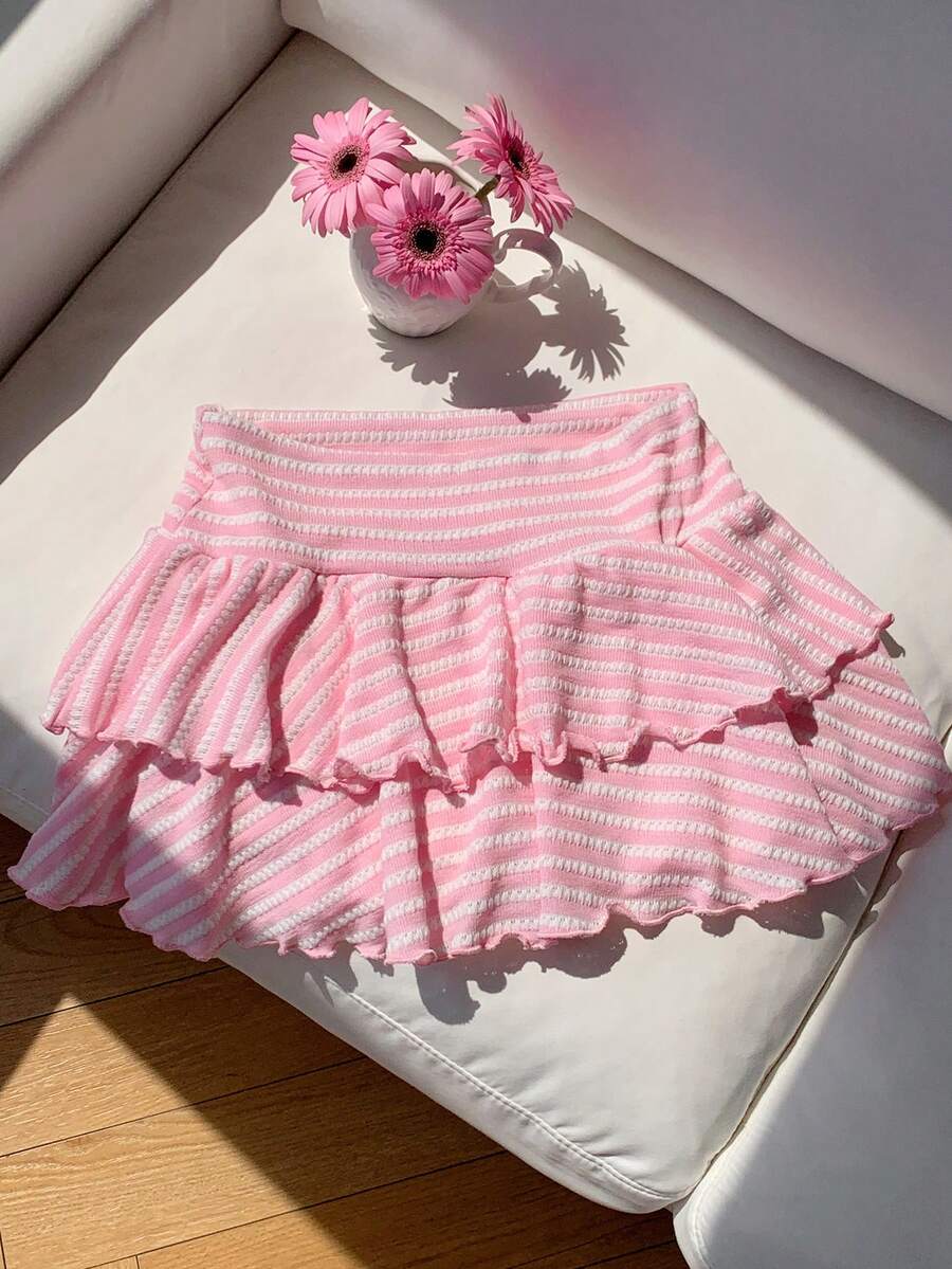 Black low waist knit mini skirt featuring a tiered ruffle hem and skinny high stretch fit.