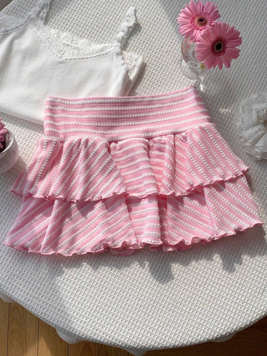Black low waist knit mini skirt featuring a tiered ruffle hem and skinny high stretch fit.