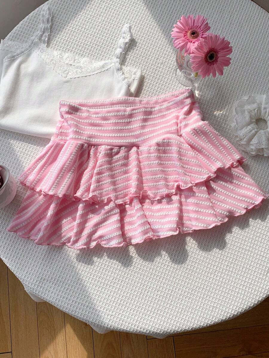 Black low waist knit mini skirt featuring a tiered ruffle hem and skinny high stretch fit.