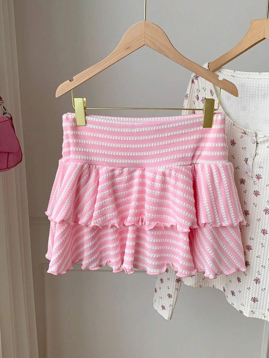 Black low waist knit mini skirt featuring a tiered ruffle hem and skinny high stretch fit.