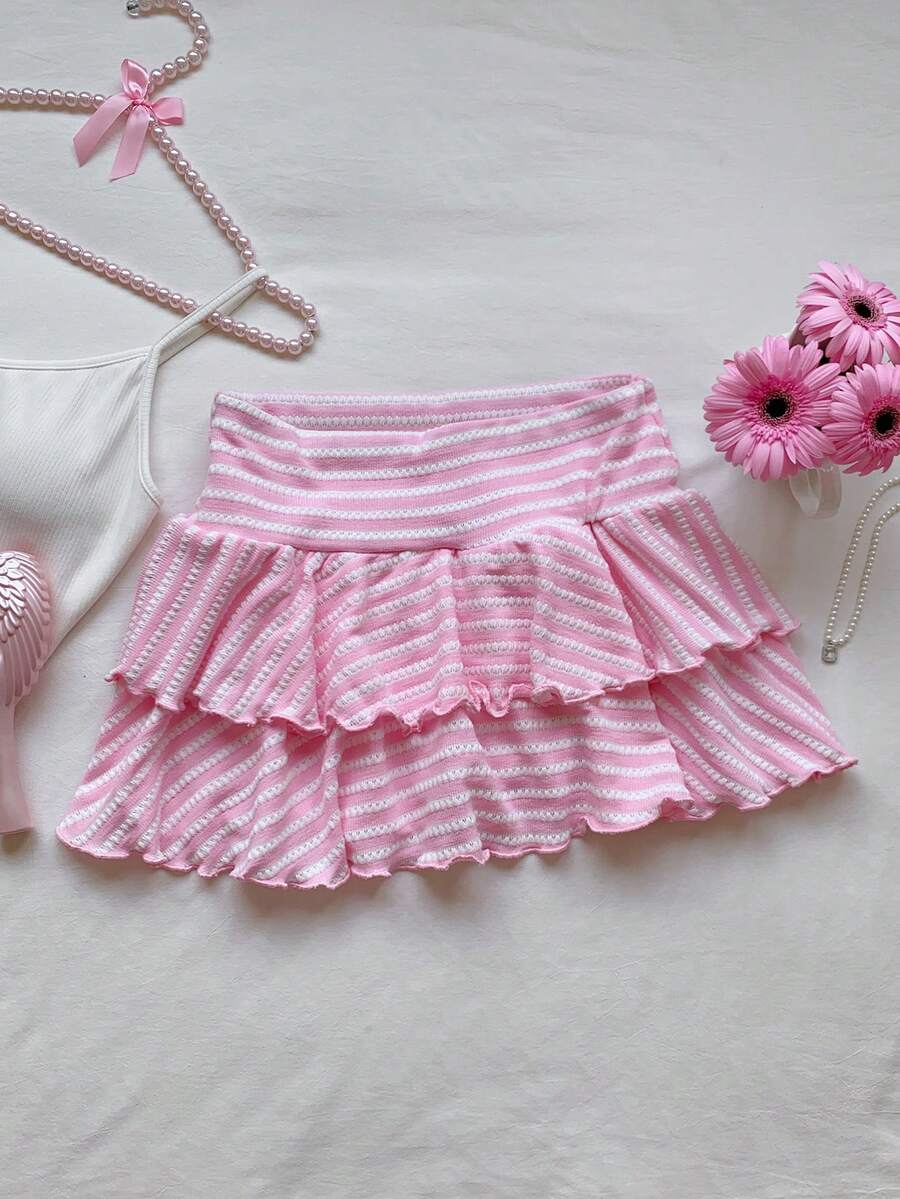 Black low waist knit mini skirt featuring a tiered ruffle hem and skinny high stretch fit.