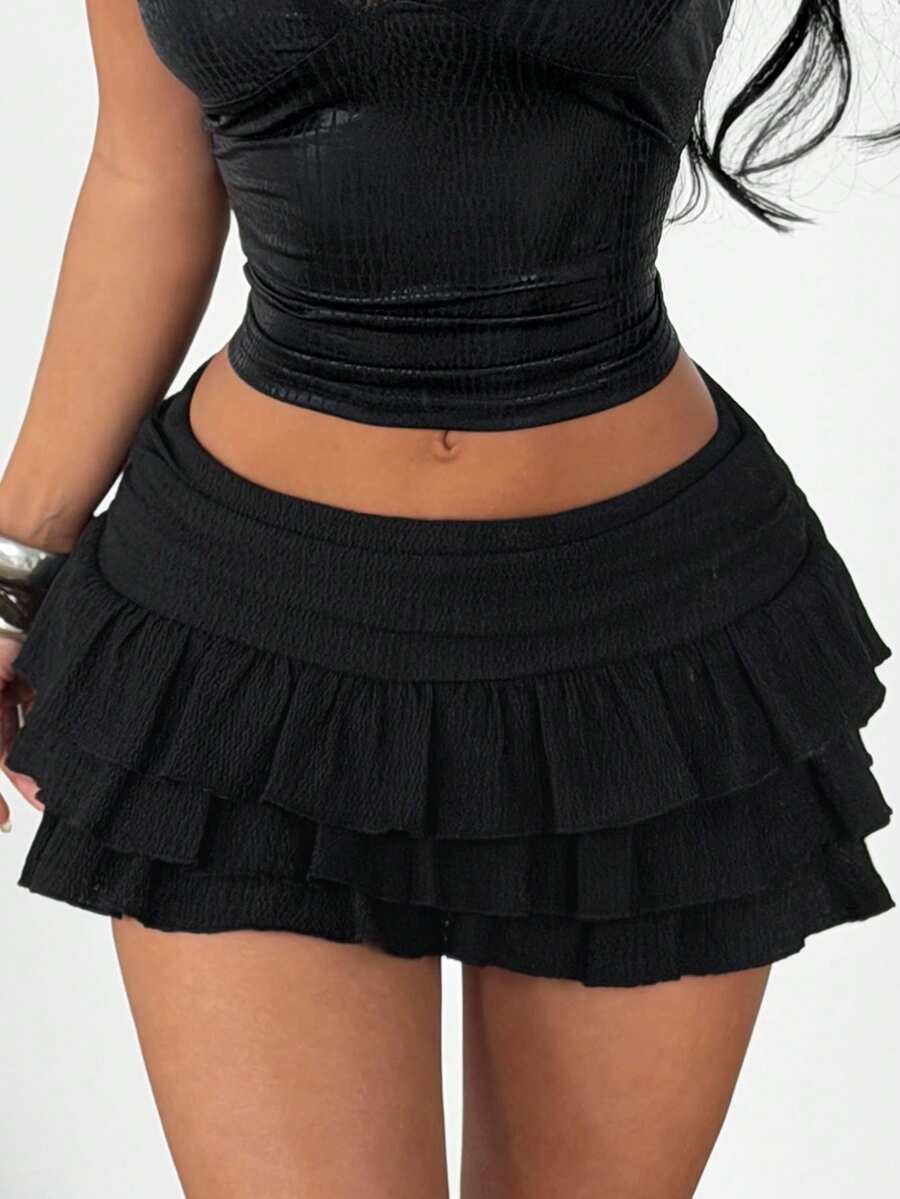 Women's black ruffle tiered mini skirt with low waist and slight stretch knitted fabric.