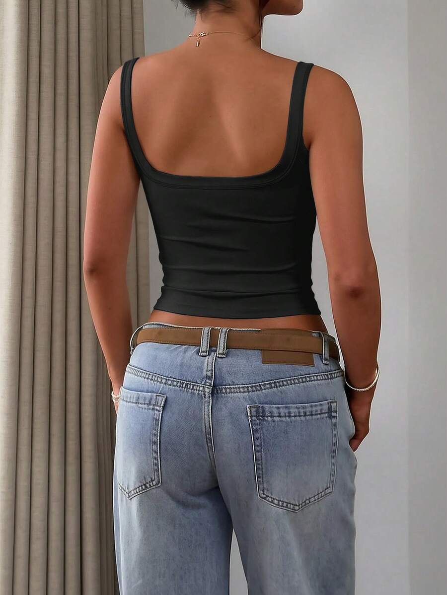 A slim fit women's crop cami tank top with spaghetti straps and a solid color design, made from comfortable stretch knitted fabric.