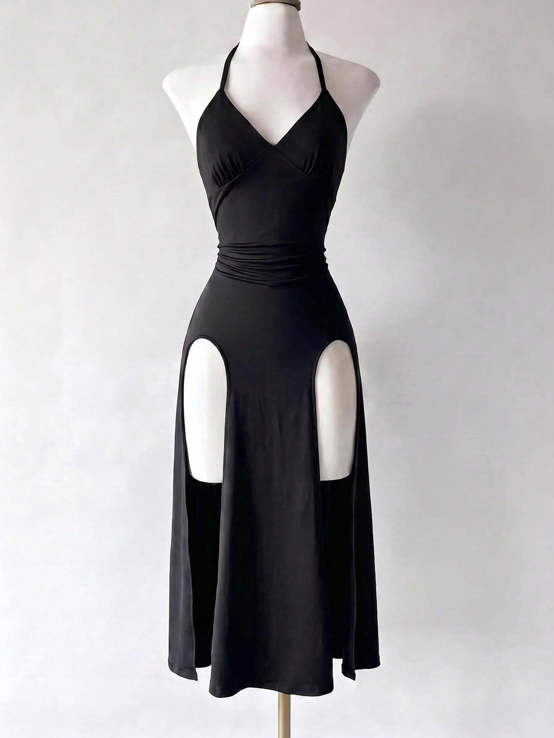 Black knitted sleeveless halter dress featuring cut out detailing, high waist, and side slit hem.