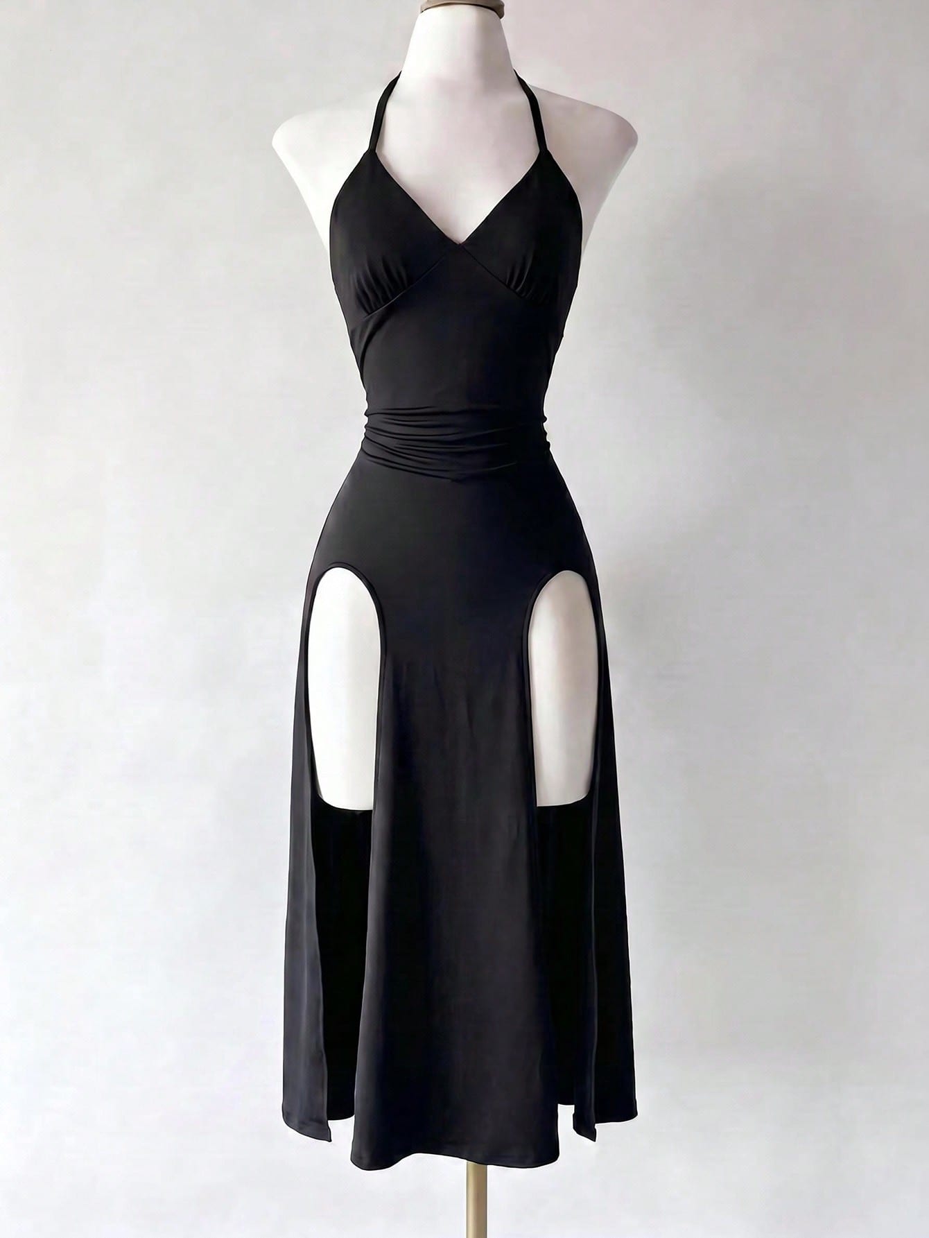 Black knitted sleeveless halter dress featuring cut out detailing, high waist, and side slit hem.