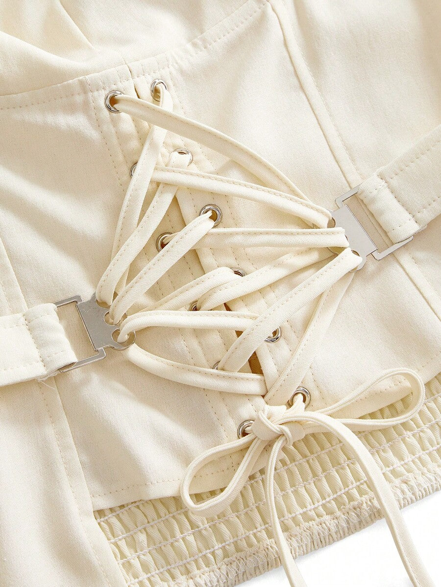 White lace-up crop camisole top for women featuring grommet eyelet details, a sweetheart neckline, shirred back, and asymmetrical hem.