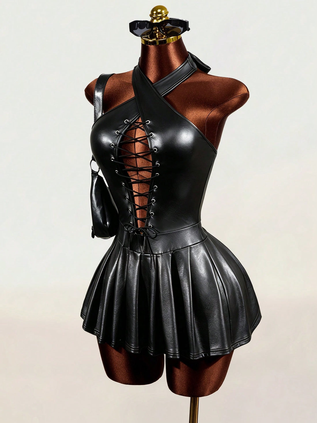 Black halter mini dress with cold shoulder design, contrast mesh detail, and flared A-line hem.