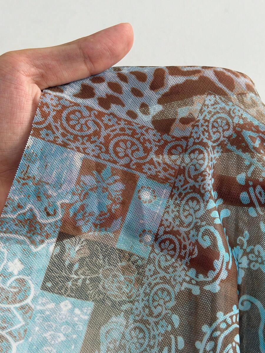 Women's blue and brown graphic print long flared skirt with low waist, split thigh detail, and textured semi-sheer fabric.