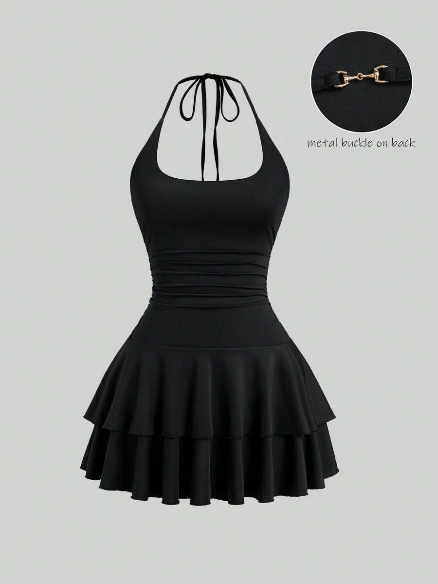 Black sleeveless tiered cami mini dress for women featuring a plain pattern, halter neckline, tie back detail, and layered hem.