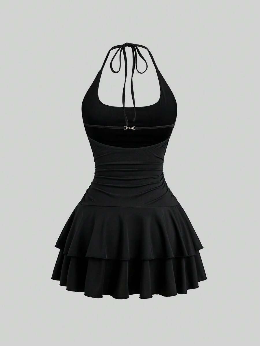 Black sleeveless tiered cami mini dress for women featuring a plain pattern, halter neckline, tie back detail, and layered hem.