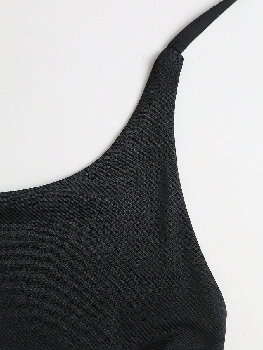 Black sleeveless tiered cami mini dress for women featuring a plain pattern, halter neckline, tie back detail, and layered hem.