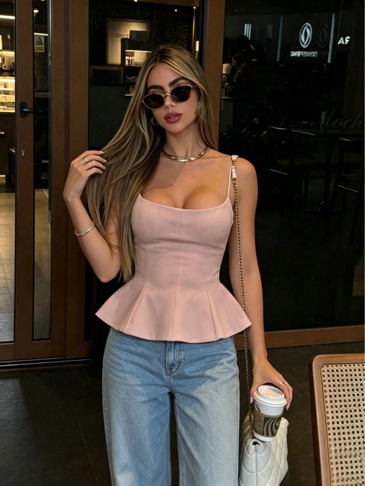 A sleeveless cropped camisole top featuring thin spaghetti straps, a slim fit bodice, and a subtle flared hemline.