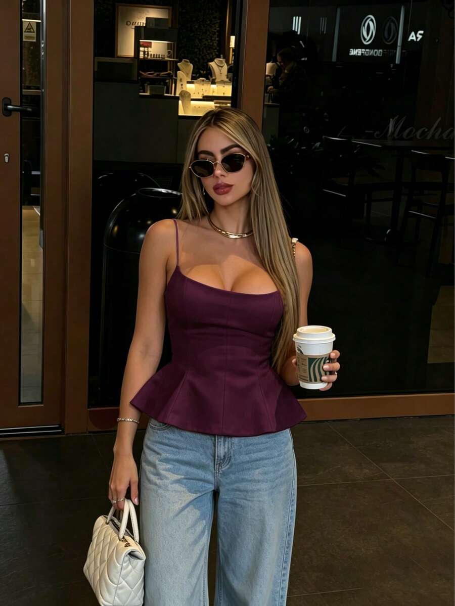 A sleeveless cropped camisole top featuring thin spaghetti straps, a slim fit bodice, and a subtle flared hemline.