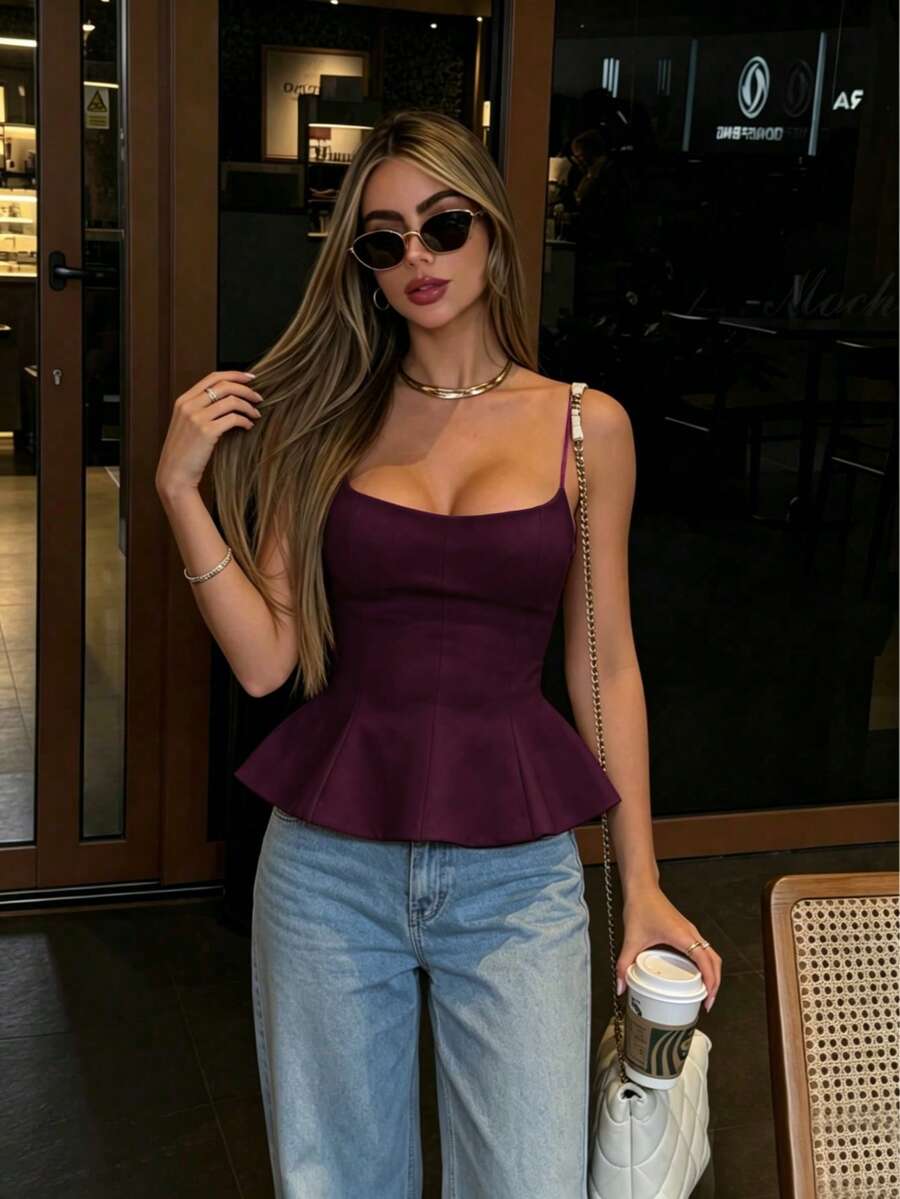 A sleeveless cropped camisole top featuring thin spaghetti straps, a slim fit bodice, and a subtle flared hemline.