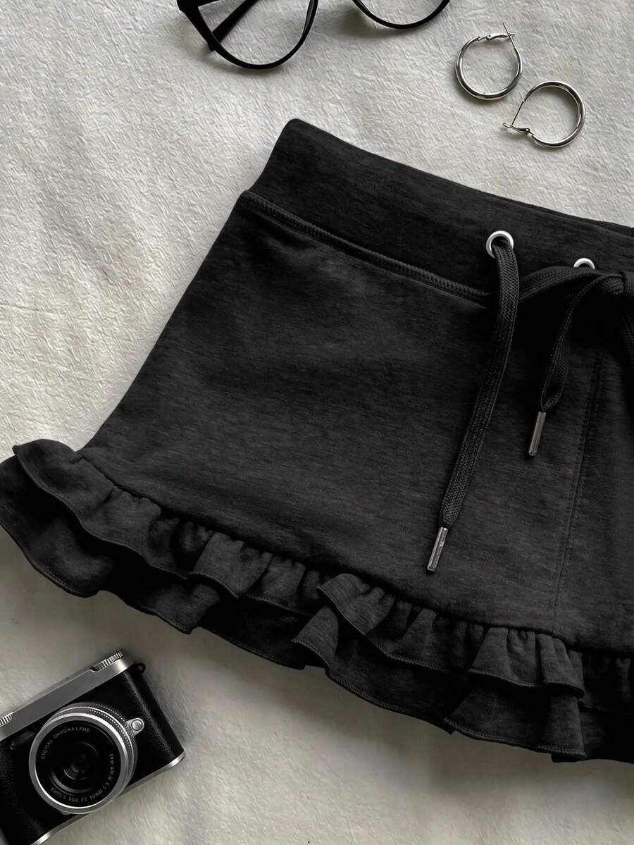 Women's plain black ultra low waist bodycon mini skirt with frill detailing in knitted stretch fabric.
