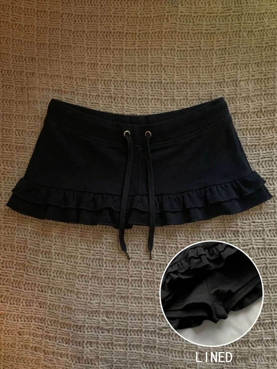 Women's plain black ultra low waist bodycon mini skirt with frill detailing in knitted stretch fabric.