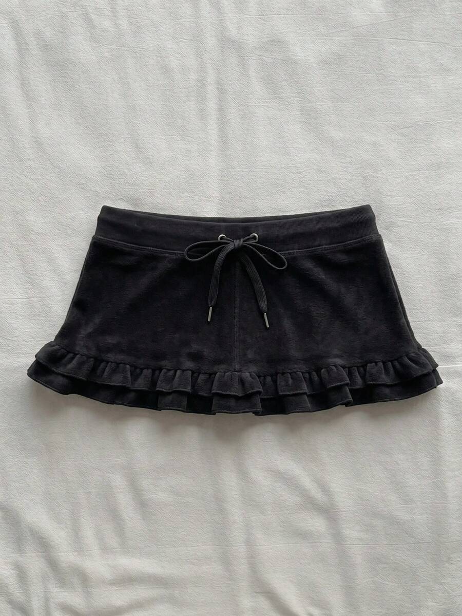 Women's plain black ultra low waist bodycon mini skirt with frill detailing in knitted stretch fabric.