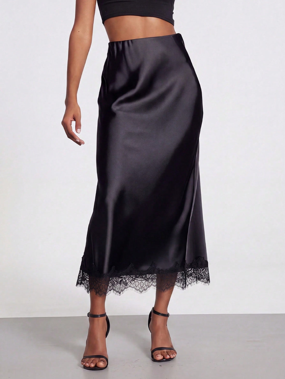 Women's black lace patchwork satin skirt featuring a long bodycon silhouette and natural mid waist design.