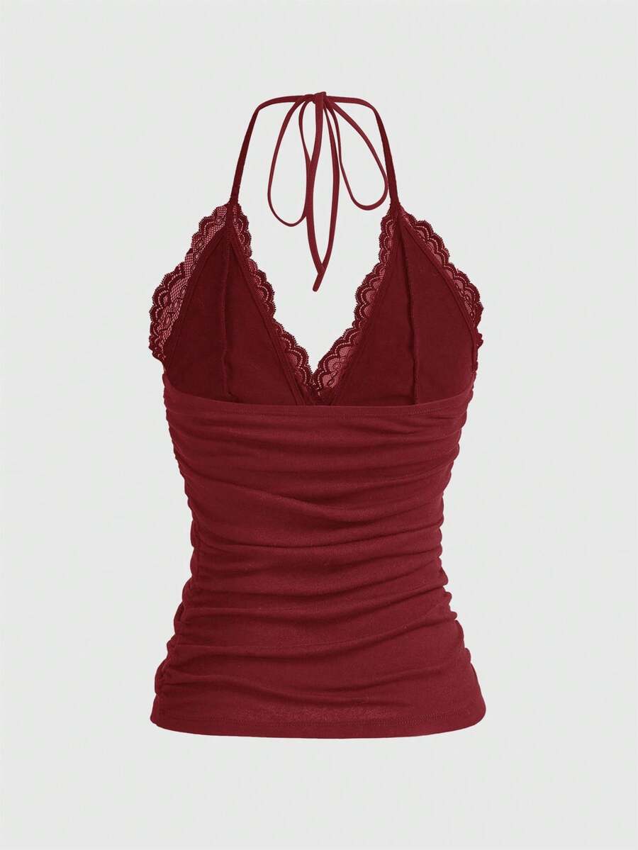 A women's black backless halter top featuring contrast lace trim, ruched front detail, and slim fit soft knitted fabric.
