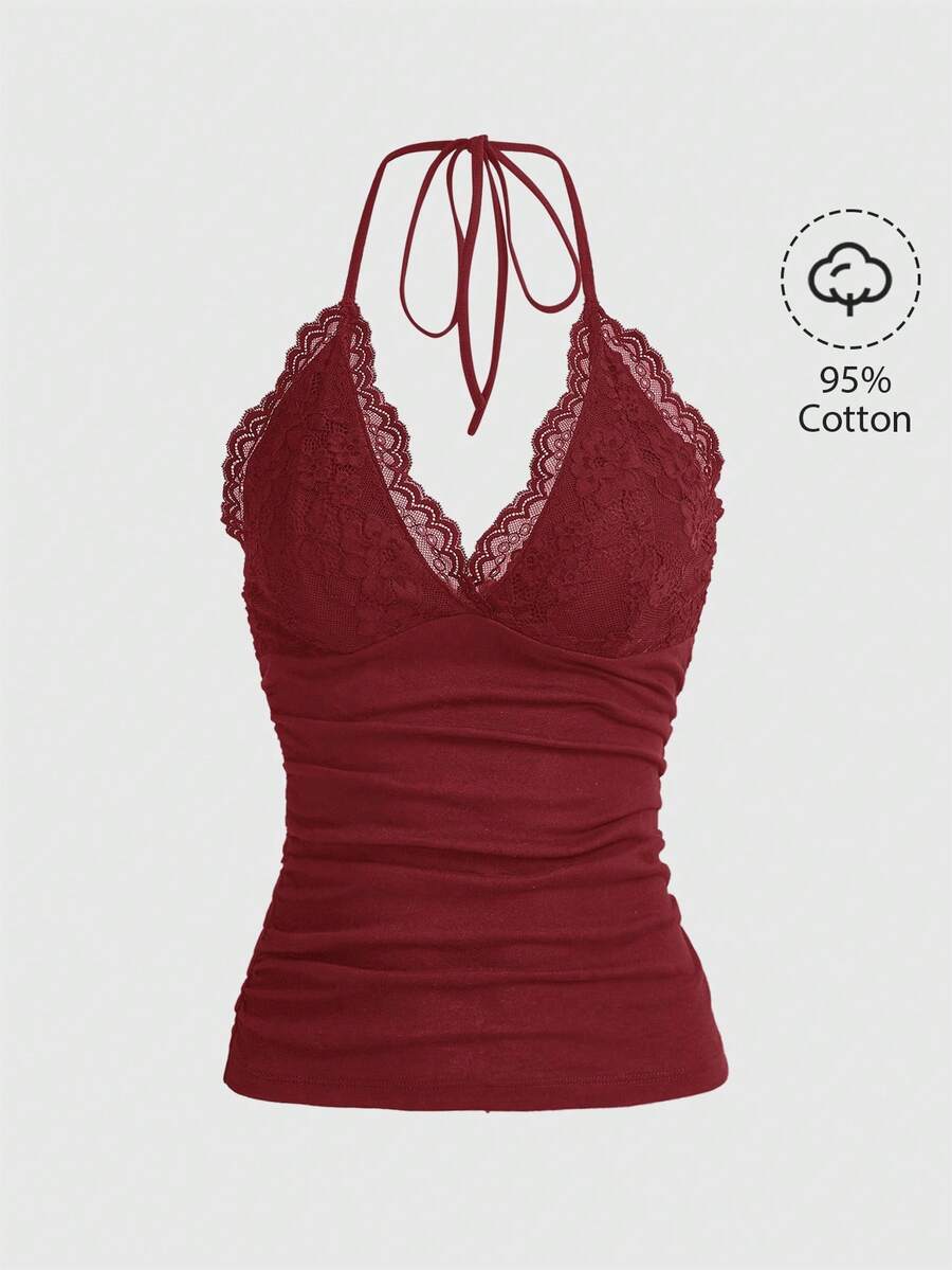 A women's black backless halter top featuring contrast lace trim, ruched front detail, and slim fit soft knitted fabric.