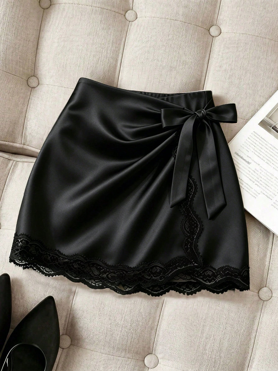 Women's black satin wrap mini skirt featuring contrast lace trim and mid-waist design.