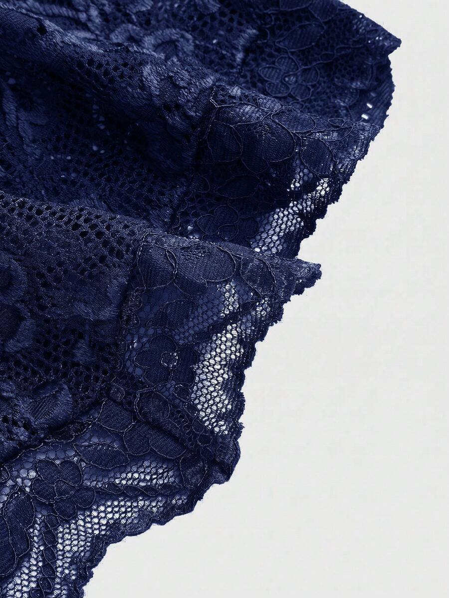 Women's black lace halter neck camisole featuring a backless crop silhouette, contrast lace trim, and scallop hem.