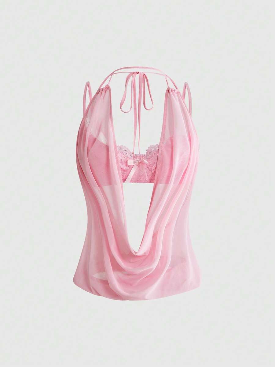 Women wearing a black draped backless halter crop top layered over a boned lace camisole.