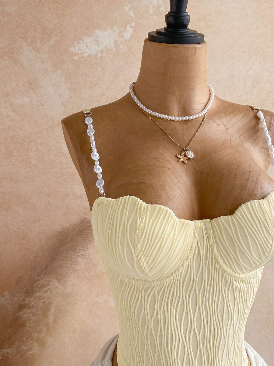 Women's black molded cup camisole top with scallop detailing and spaghetti straps.