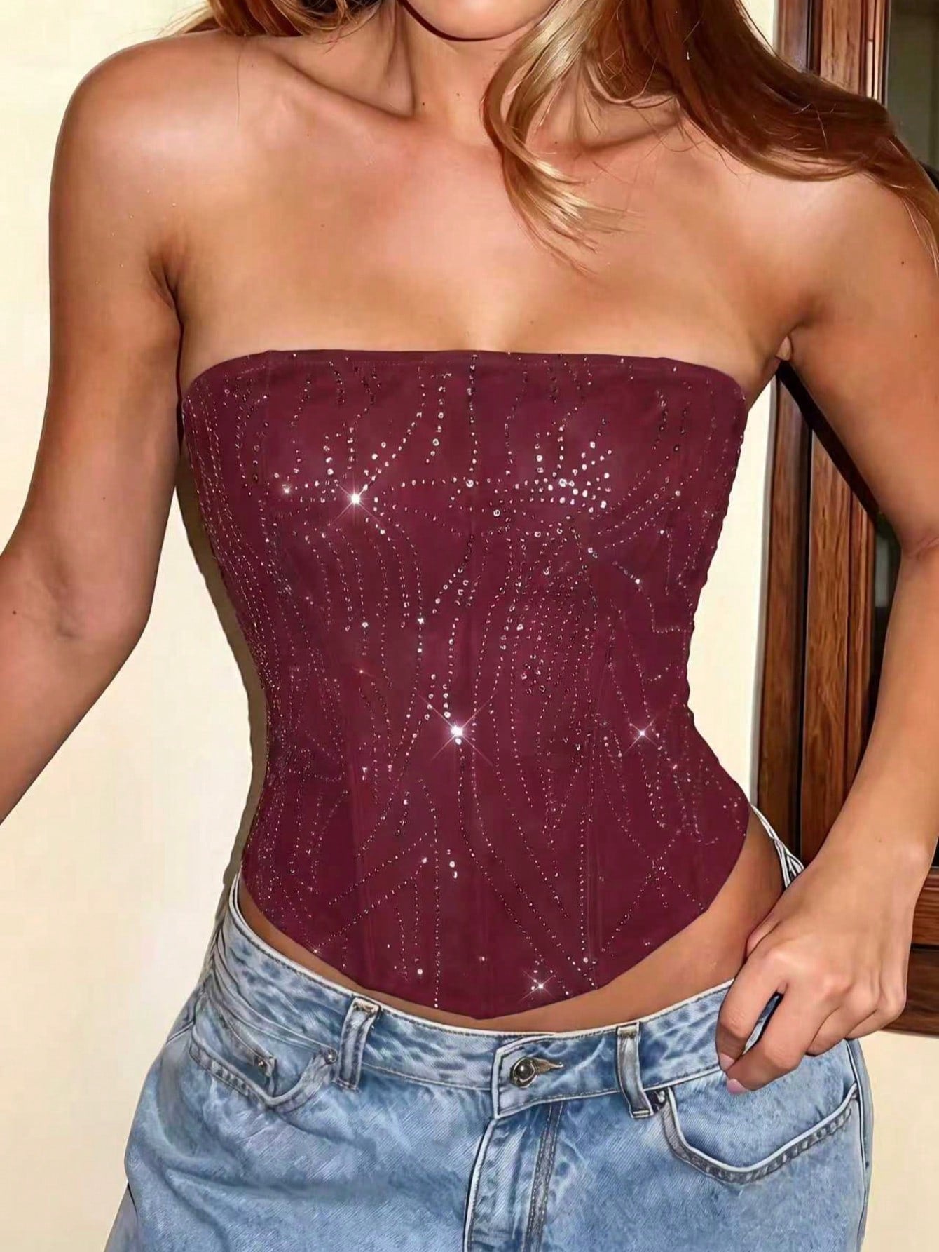 Black strapless corset tube top with sparkling rhinestone decor, boned silhouette, and lace-up tie back.