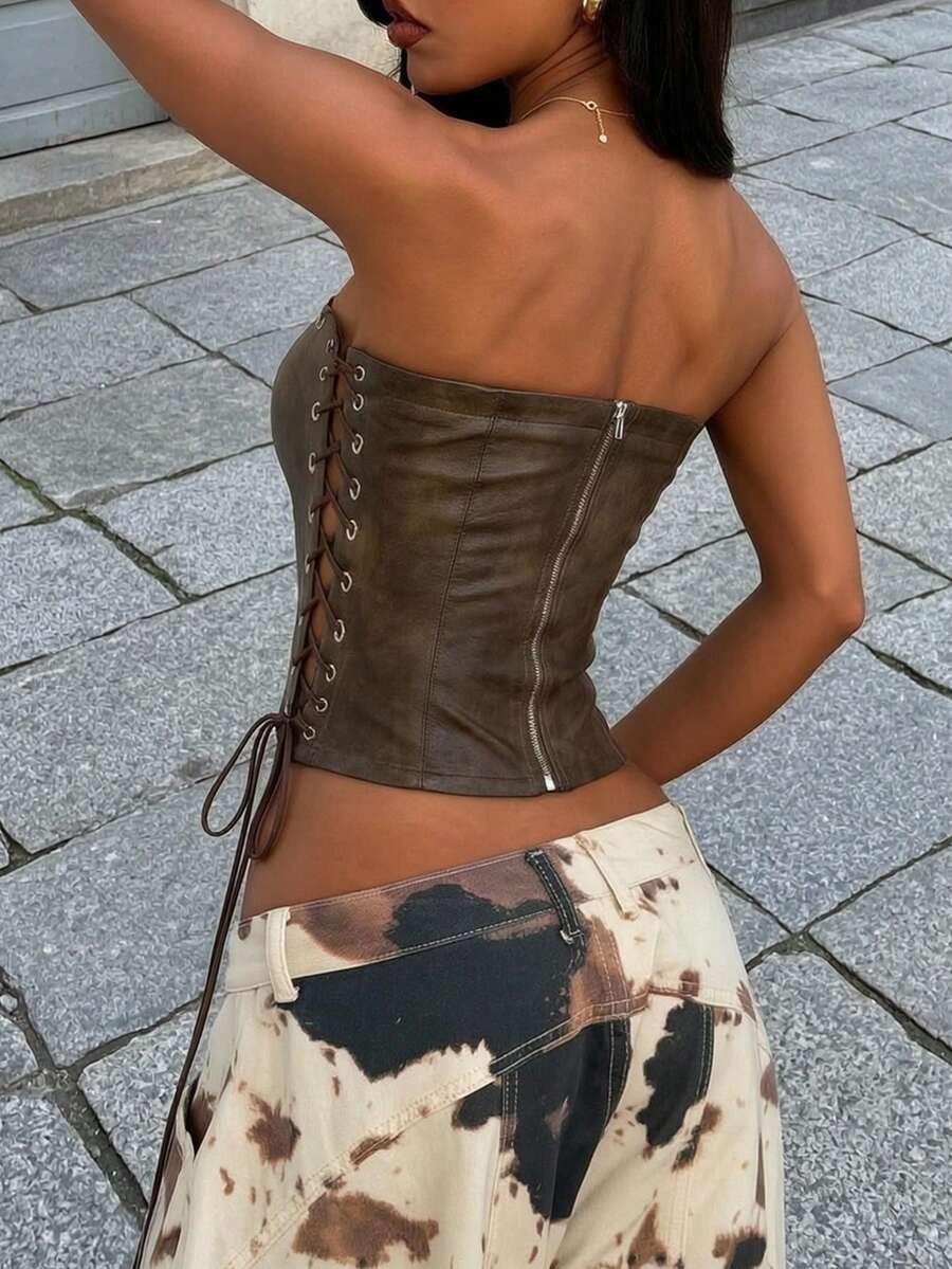 Women’s coffee brown faux leather lace-up crop top with strapless neckline, slit hem, and slim fitted silhouette for festival and nightlife wear.