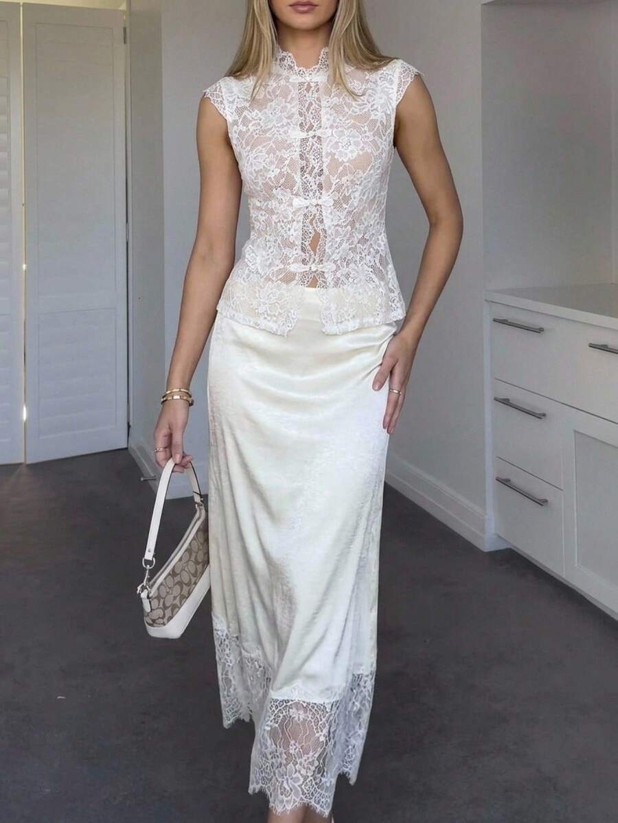 Woman wearing an elegant apricot satin maxi skirt featuring delicate contrast lace trim, a low waist design, and a flowing A-line silhouette.