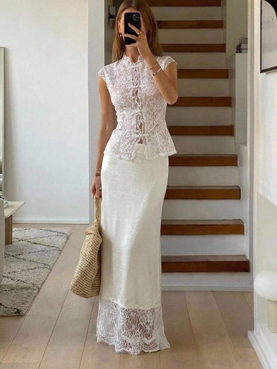 Woman wearing an elegant apricot satin maxi skirt featuring delicate contrast lace trim, a low waist design, and a flowing A-line silhouette.