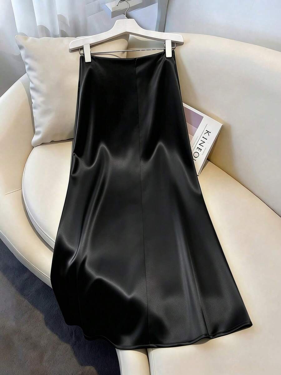 Women's elegant black A-line long skirt featuring a plain woven fabric, regular fit, natural mid-waist style, and flared hem design suitable for formal and evening wear.