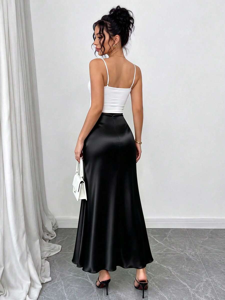 Women's elegant black A-line long skirt featuring a plain woven fabric, regular fit, natural mid-waist style, and flared hem design suitable for formal and evening wear.