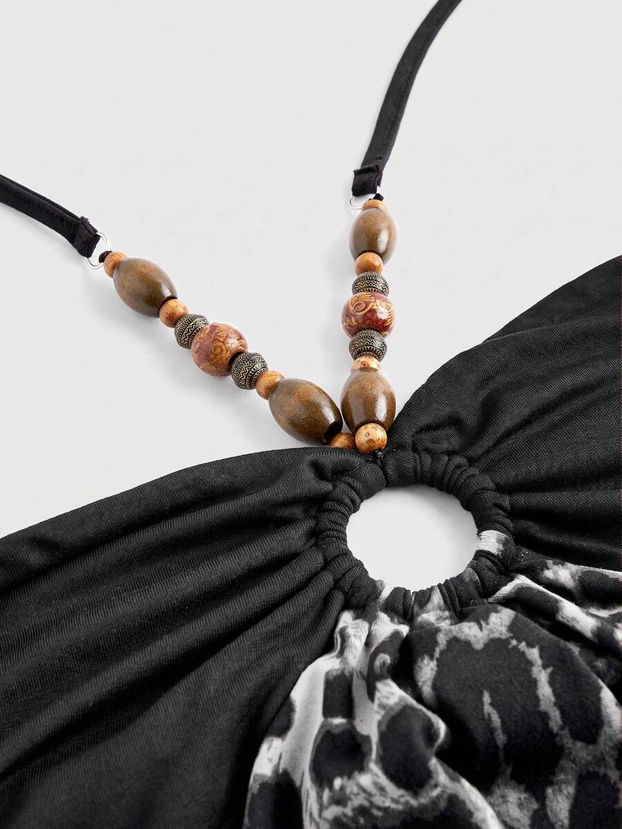 Women's black Y2K halter neck backless bodycon mini dress featuring beaded decor, textured patchwork pattern, natural waist, and slim fit pencil hem.