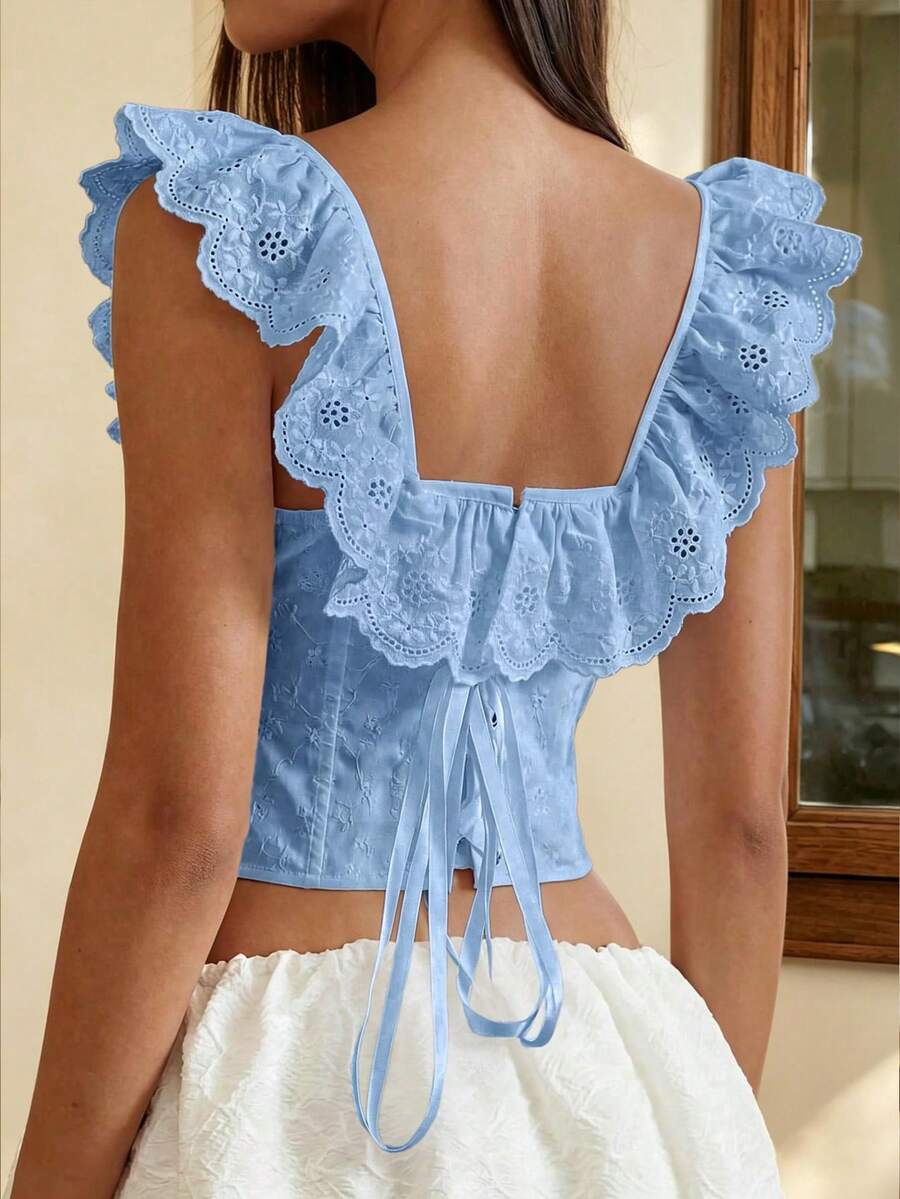 Women’s white corset top with embroidered ruffle trim, off-shoulder neckline, lace-up details, front hook closure, and sleeveless crop fit.