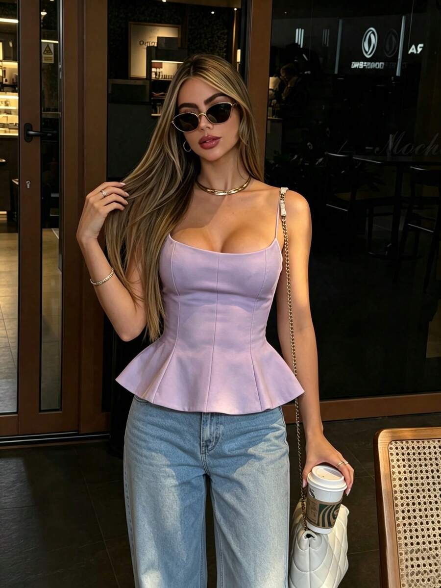 A sleeveless cropped camisole top featuring thin spaghetti straps, a slim fit bodice, and a subtle flared hemline.